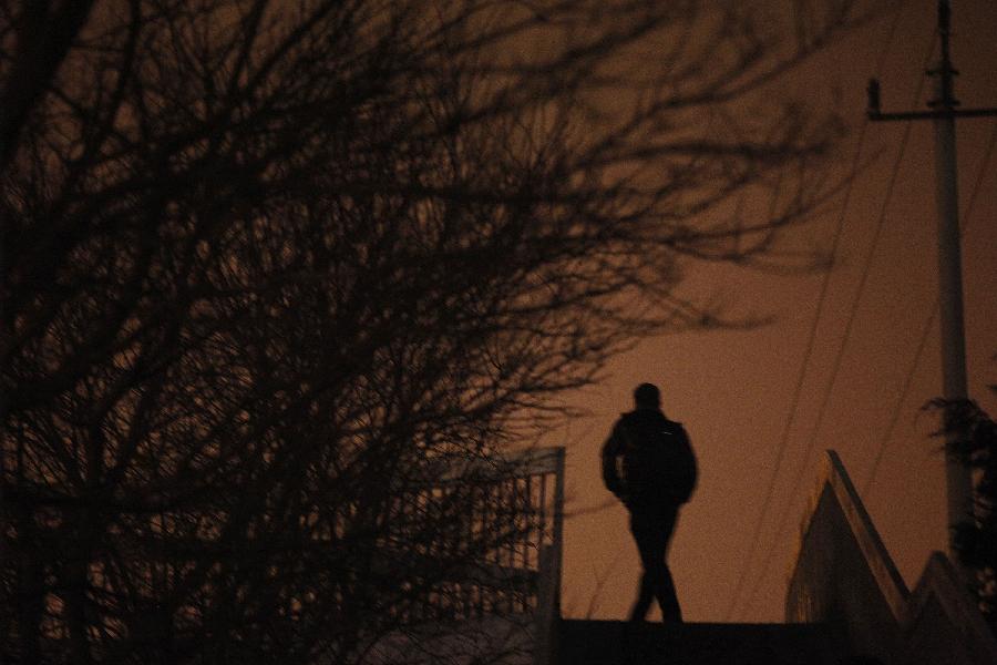 A pedestrian on an overpass is silhouetted in the fog in Beijing, capital of China, Jan. 22, 2013. Beijing meteorological observatory issued a yellow alert for heavy fog on Tuesday. (Xinhua/Wang Shen)