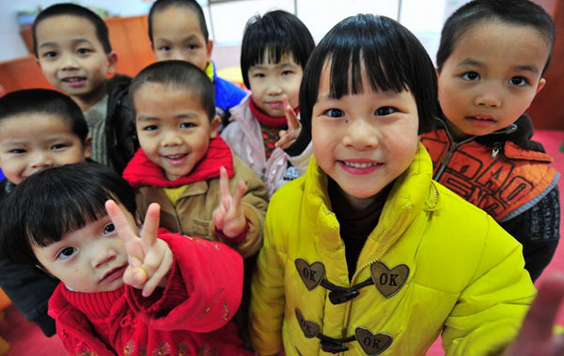 Kids pose for a photo at a orphanage in Jinjiang, Fujian province, Jan 22. The 23 children were abducted by kidnappers to sell until they rescued by police in 2005, but they have been unable to trace their parents. (Photo/Xinhua) 