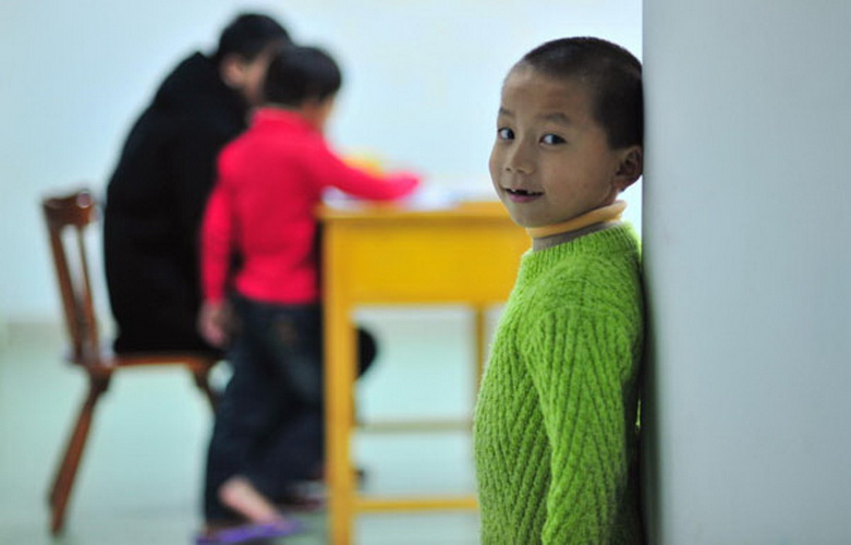 Jiang Shan, 8, (right) attends class at a orphanage in Jinjiang, Fujian province, Jan 22. Jiang lives here with 23 children who were abducted by kidnappers to sell until they were rescued by police in 2005, but they have been unable to trace their parents. As Spring Festival approaches, all miss their parents and home a lot, but sadly most don't remember their real names. Police believe they are from remote villages in Guizhou, Sichuan or Hunan provinces. (Photo/Xinhua) 