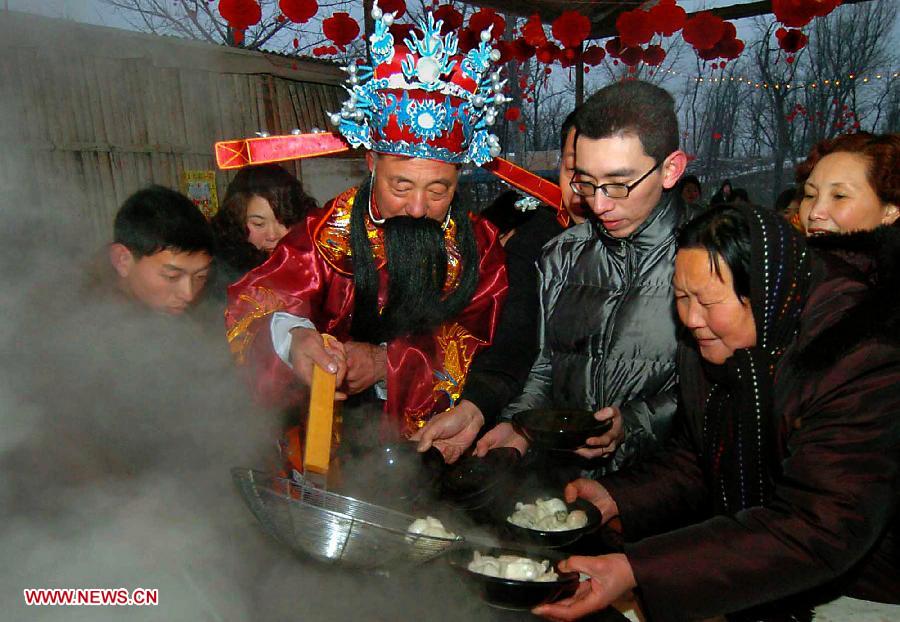 File photo taken on Feb. 8, 2005 shows a man dressed as the "Kitchen God" serves visitors with dumplings at a temple fair in Zhengzhou, capital of central China's Henan Province. Temple fair in central China area is an important social activity for local people. The ancient temple fairs in central China were ceremonious sacrificial rituals. As time goes by, the focus of temple fair activities has shifted from "gods" to "people". The modern temple fair in central China is a platform of displaying folk culture as well as a channel for commodity circulation. According to statistics from the provincial cultural sector, there are about 35,000 temple fairs each year in Henan. (Xinhua/Wang Song)
