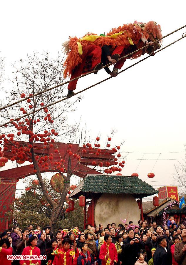 File photo taken on Jan. 28, 2009 shows folk artisans perform lion dance in the air at a temple fair in Zhengzhou, capital of central China's Henan Province. Temple fair in central China area is an important social activity for local people. The ancient temple fairs in central China were ceremonious sacrificial rituals. As time goes by, the focus of temple fair activities has shifted from "gods" to "people". The modern temple fair in central China is a platform of displaying folk culture as well as a channel for commodity circulation. According to statistics from the provincial cultural sector, there are about 35,000 temple fairs each year in Henan. (Xinhua/Wang Song)