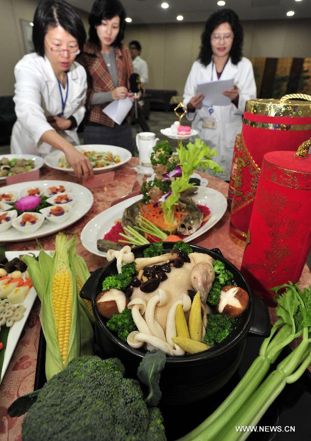 Dieticians from Taiwan University Hospital introduce the nutrition standards of creative dishes to media reporters in Taipei, southeast China's Taiwan, Jan. 23, 2013. Dieticians from Taiwan University Hospital created ten dishes mostly made from vegetables and fruits, promoting a healthy dinner in the coming Spring Festival. (Xinhua/Wu Ching-teng)