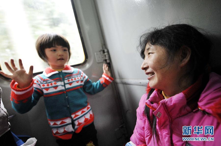 Li Siyi (Left) tries to amuse her mother during the long and dull time aboard the train, Jan. 17, 2013. Li and her mother had to stand for more than 30 hours on the train because of the difficulty in getting ticket with seat during the festival travel peak. (Photo/Xinhua)