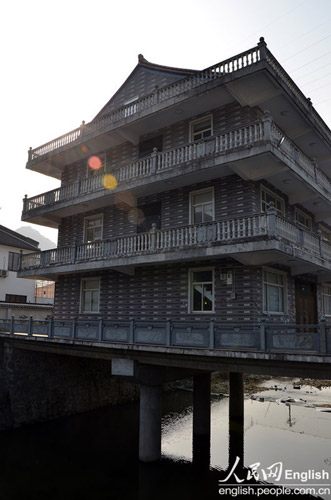 A building built on a bridge in Wenling, Zhejiang, on Jan 22, 2013.(Photo/CFP)