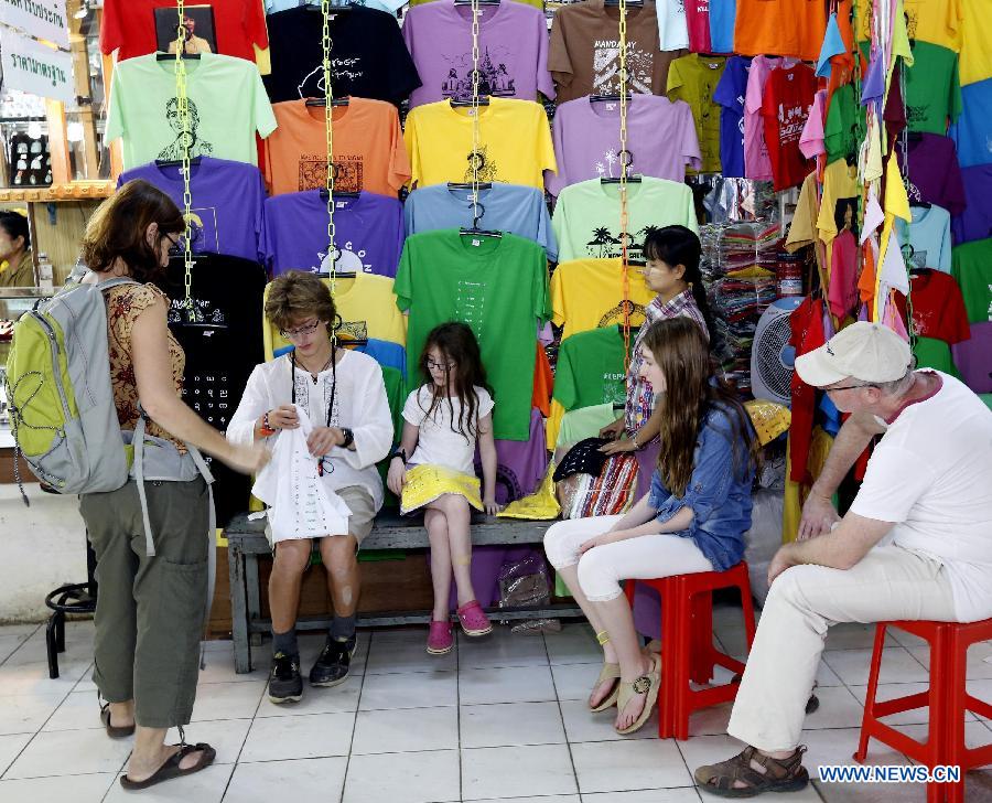 Tourists select clothes at a shop in Yangon, Myanmar, on Jan. 24, 2013. Significant reforms and increased exchanges with the international community brought Myanmar over one million person-time of foreign tourists in 2012. (Xinhua/U Aung)