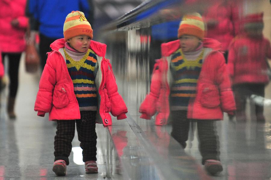 A child walks at Tianjin train station in north China's Tianjin Municipality, Jan. 25, 2013. The 40-day Spring Festival travel will begin on Jan. 26. The Spring Festival, the most important occasion for a family reunion for the Chinese people, falls on the first day of the first month of the traditional Chinese lunar calendar, or Feb. 10 this year. The number of passengers would reach 3.407 billion person-time during the 2013 Spring Festival travel, an 8.6 percent increase year on year. (Xinhua/Liu Zerui)