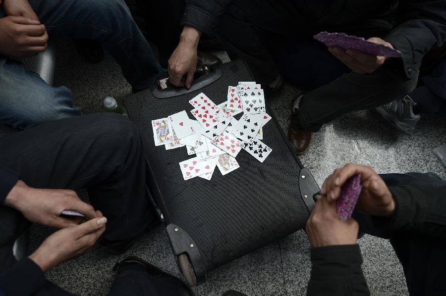 Passengers play cards while waiting to board trains at the Yinchuan Railway Station in Yinchuan, capital of northwest China's Ningxia Hui Autonomous Region, Jan. 25, 2013. The most important Chinese holiday, the Spring Festival, falls on Feb. 10 and migrants want to get home to see their families. The Ministry of Railways forecast the holiday travel rush, which starts on Jan. 26, will last until March 6. (Xinhua/Wang Peng) 