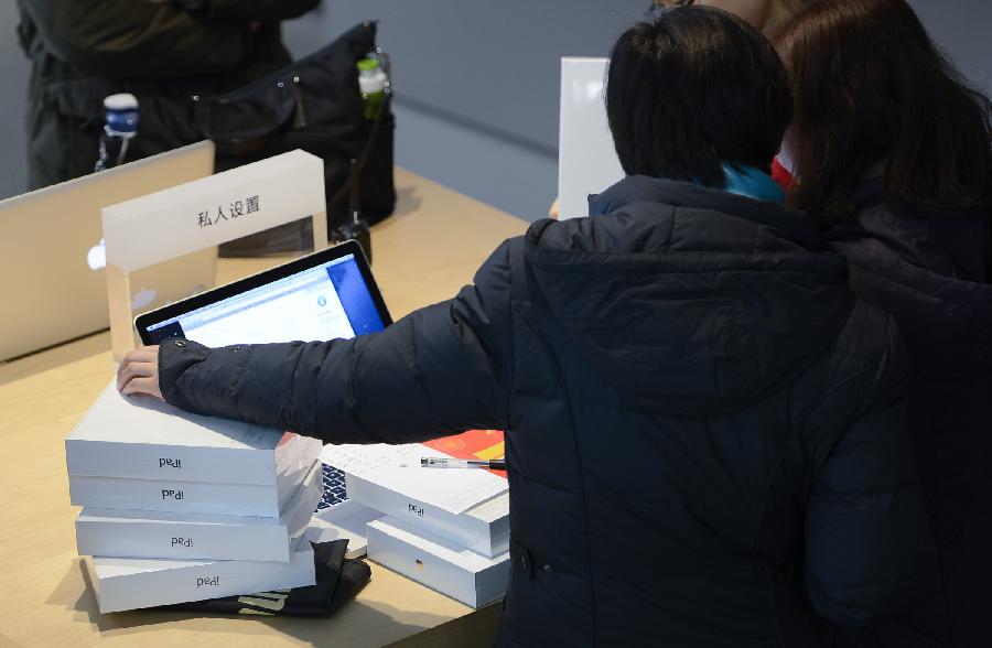 Customers choose apple products at Wangfujin Apple Store in Beijing, capital of China, Jan. 25, 2013. Apple Store held a sales activity on Friday, during which customers could enjoy special pricing online and at Apple retail stores on apple products. (Xinhua/Qi Heng)