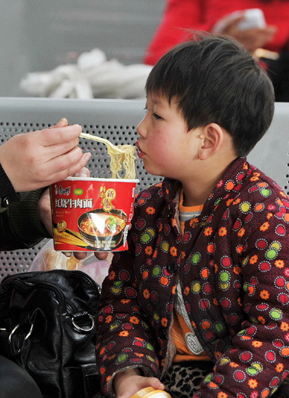 A boy eats noodles at Yinchuan Railway Station, Jan 26, 2013. (Photo/Xinhua) 