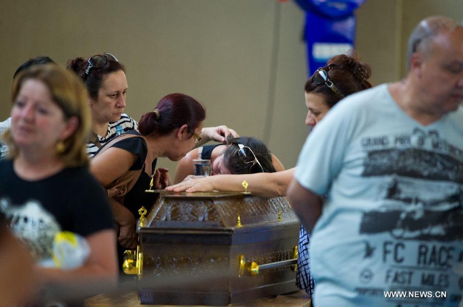 Relatives of a victim mourn over a coffin in the municipal sports center where the bodies of the nightclub fire victims are placed, in Santa Maria, state of Rio Grande do Sul, southern Brazil, on Jan. 27, 2013. A nightclub fire that broke out in Santa Maria early Sunday killed at least 245 people, according to a local TV report. (Xinhua/AGENCIA ESTADO) 