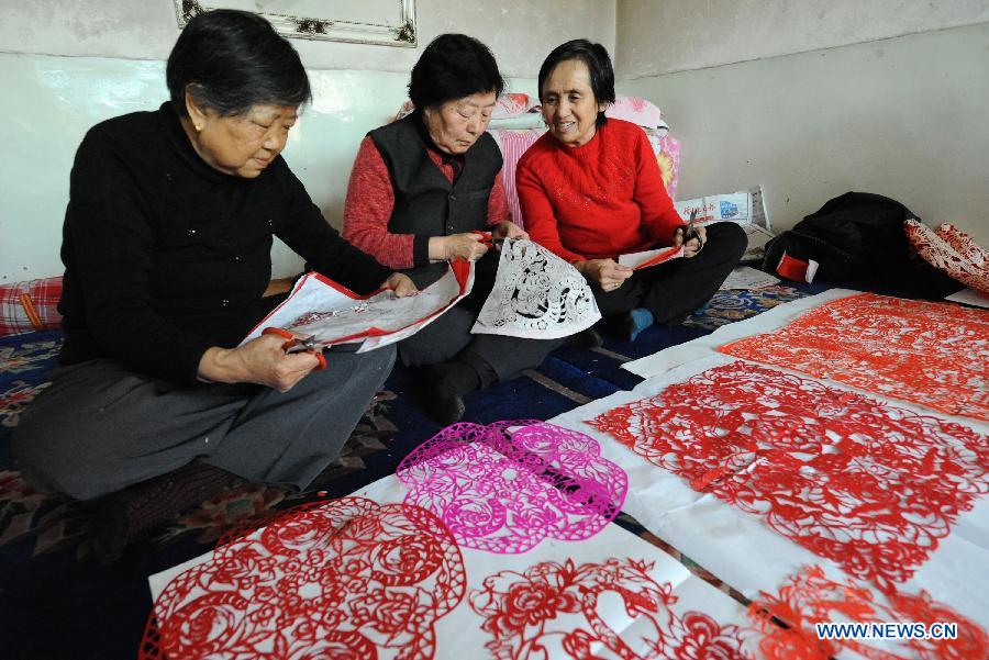 Women make paper cuttings in Shenmu County of northwest China's Shaanxi Province, Jan. 28, 2013. People began to make paper cuttings for the decoration of the upcoming Spring Festival here in recent days. (Xinhua/Li Yibo)