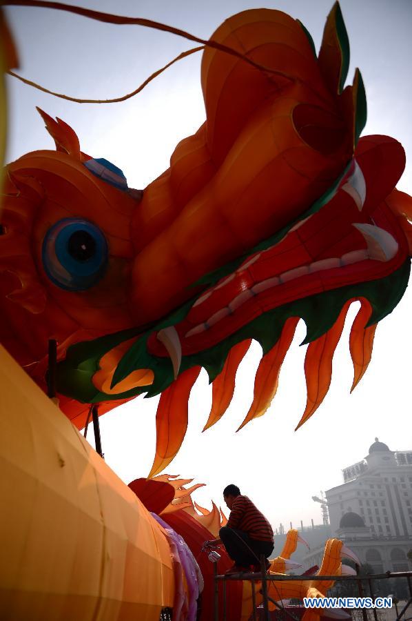 A man works on a lantern in the shape of Chinese dragon on the street in Nanchang, capital of east China's Jiangxi Province, Jan. 28, 2013. Lanterns designed in Zigong of southwest China's Sichuan Province will meet with the residents here during the upcoming Spring Festival holiday. (Xinhua/Zhou Mi)