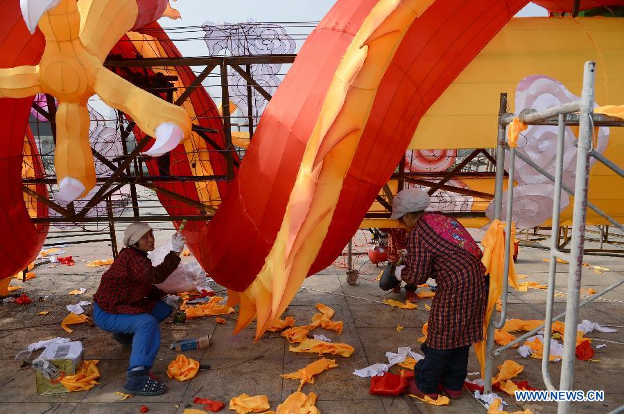 Women work on a lantern in the shape of Chinese dragon on the street in Nanchang, capital of east China's Jiangxi Province, Jan. 28, 2013. Lanterns designed in Zigong of southwest China's Sichuan Province will meet with the residents here during the upcoming Spring Festival holiday. (Xinhua/Zhou Mi)