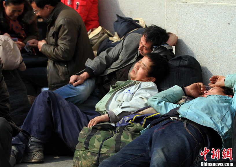 Travelers fall asleep in the waiting hall of Hankou Railway Station on Jan. 26, 2013. (CNS/Zhang Chang)