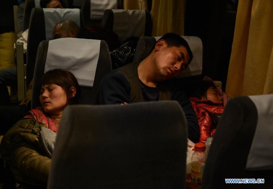 Liu Chuantao(C), his wife Chen Yan (L) and his daughter Liu Pingping rest on the seats on a train heading to Fuyang of east China's Anhui Province, Jan. 29 , 2013. (Xinhua/Huang Zongzhi) 
