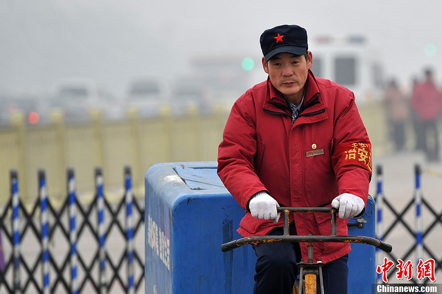 A photo taken on Jan. 29 shows a sanitation worker working the smog-shrouded street. The fourth round of heavy smog in four weeks hit Beijing on Tuesday and led to serious air pollution, which has sent more people with respiratory illnesses to hospitals. However, a group of people had to stay on jobs outdoors. (Chinanews.com/Jin Shuo)