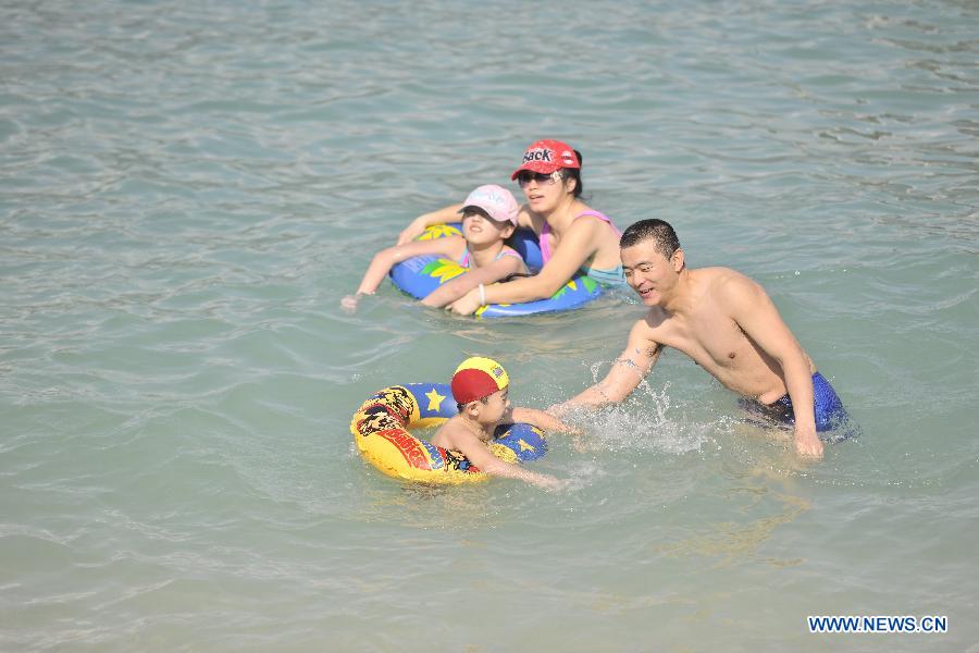 Tourists swim at the Boundary Island scenic area in Lingshui Yi Autonomous County in south China's Hainan Province, Jan. 30, 2013. Hainan launched tourism promotion with the theme of fresh air, to attract visitors from northern China where heavy haze lingered recently. (Xinhua/Zhao Yingquan)