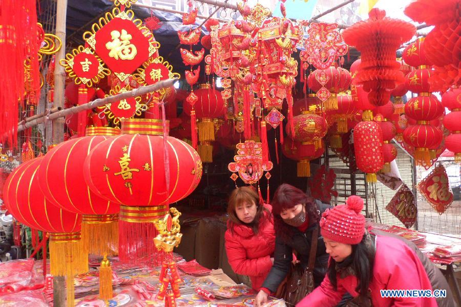 People choose decorations in a Chinese new year goods market in Kaifeng, central China's Henan Province, Jan. 30, 2013. As the spring festival drew near, people began their shopping for the celebration. (Xinhua)
