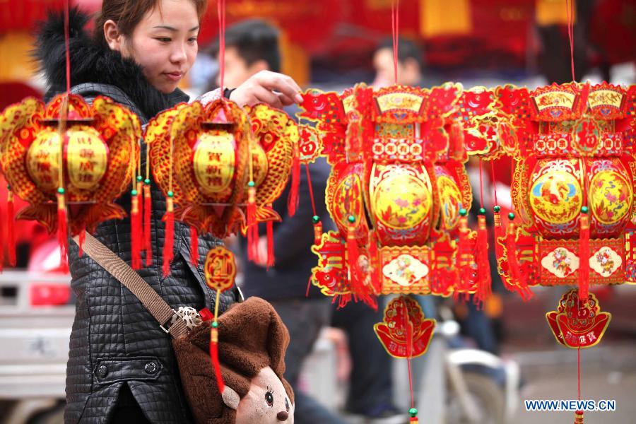 A girl chooses decorations in a Chinese new year goods market in Bozhou, east China's Anhui Province, Jan. 30, 2013. As the spring festival drew near, people began their shopping for the celebration. (Xinhua/Liu Qinli)