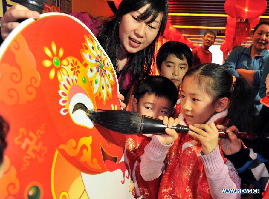 A girl draws on a lantern at a children centre in Tianjin, north China, Jan. 30, 2013. More than twenty children were invited to learn to make decorations and snacks to greet the upcoming Spring Festival which falls on Feb. 10 this year. (Xinhua/Yue Yuewei) 