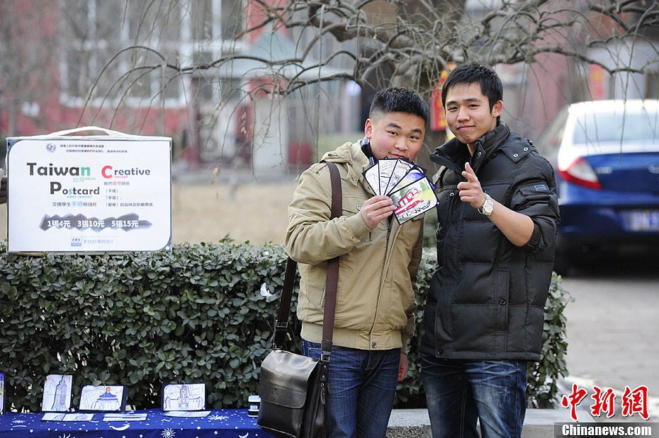 After getting a full set of Lin's hand-painted postcards, a student insists to have a photo taken with the student-artist. (Chinanews/Cui Nan)