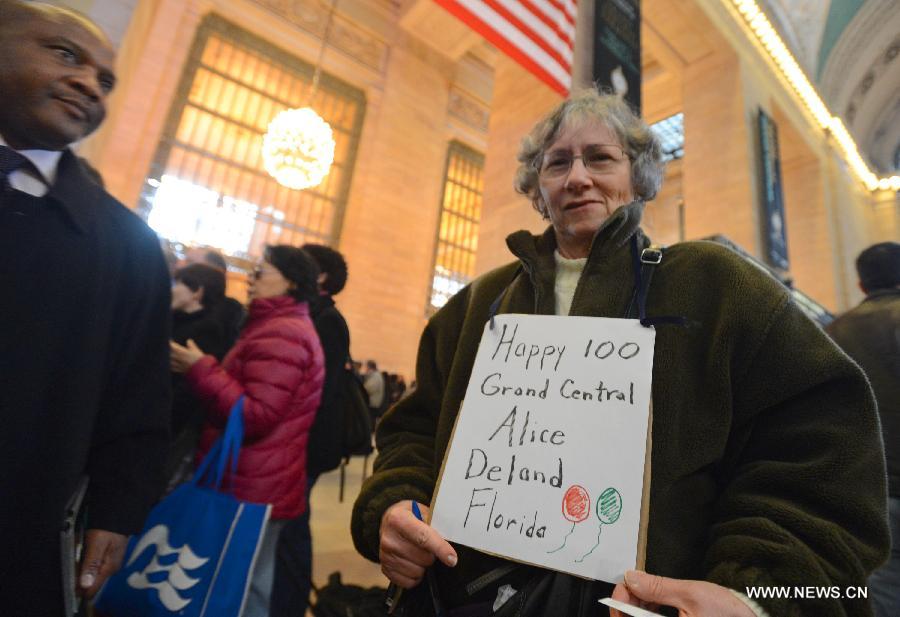 A woman holding a placard takes part in the centennial celebrations of Grand Central Terminal on the day the New York city's landmark turns 100 years old on Feb. 1, 2013. (Xinhua/Wang Lei)