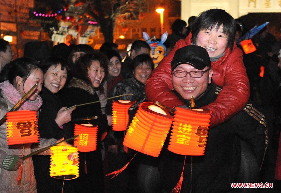 People carry lanterns during the 29th day of the 12th lunar month at a plaza in Zhengzhou, capital of central China's Henan Province, Feb. 1, 2011. It is a custom for people living in the central China region to carry lanterns on the 29th day of the 12th lunar month outdoors to pray for good luck. Chinese people who live in the central China region have formed various traditions to celebrate the Chinese Lunar New Year. (Xinhua/Wang Song)