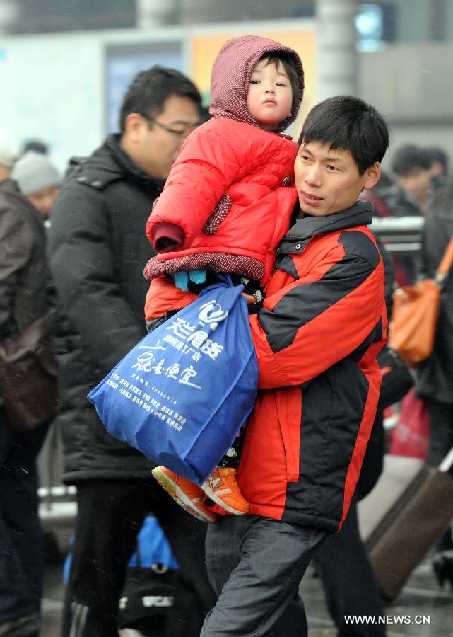 A man carries his child at the Beijing West Railway Station in Beijing, capital of China, Feb. 3, 2013. Many children travel with their families during the 40-day Spring Festival travel rush which started on Jan. 26. (Xinhua/Chen Shugen)
