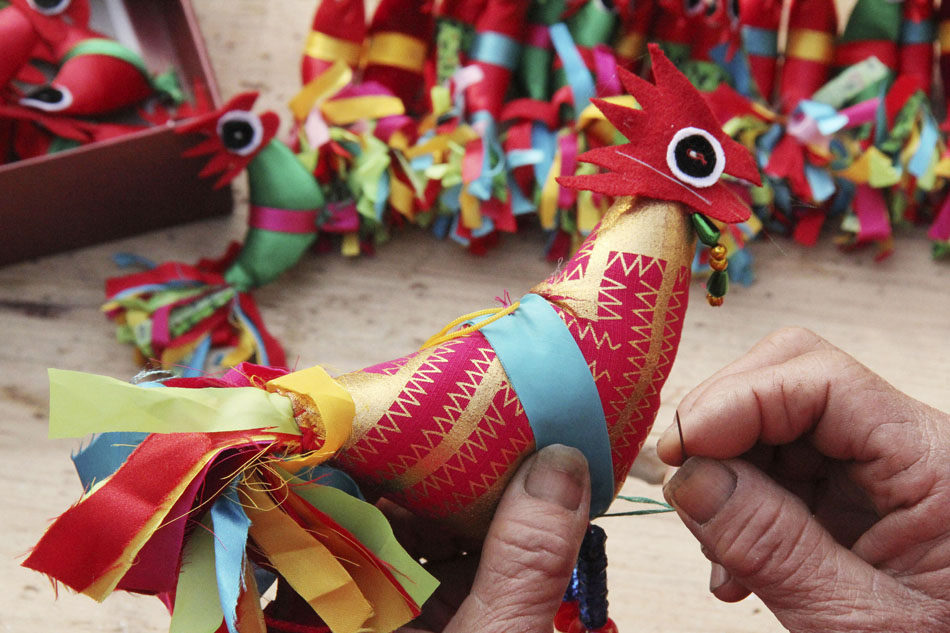 Jiang Jixia, an old craftsman from Tancheng county of Shandong province makes "Spring Cocks" for the coming Spring Festival on Jan. 27, 2013. In the rural areas of South Shandong, people have the tradition to wear the "Spring Cock" on children's hat and sleeves to bless the children with peace and prosperity in the year to come. (Xinhua/Zhang Chunlei)