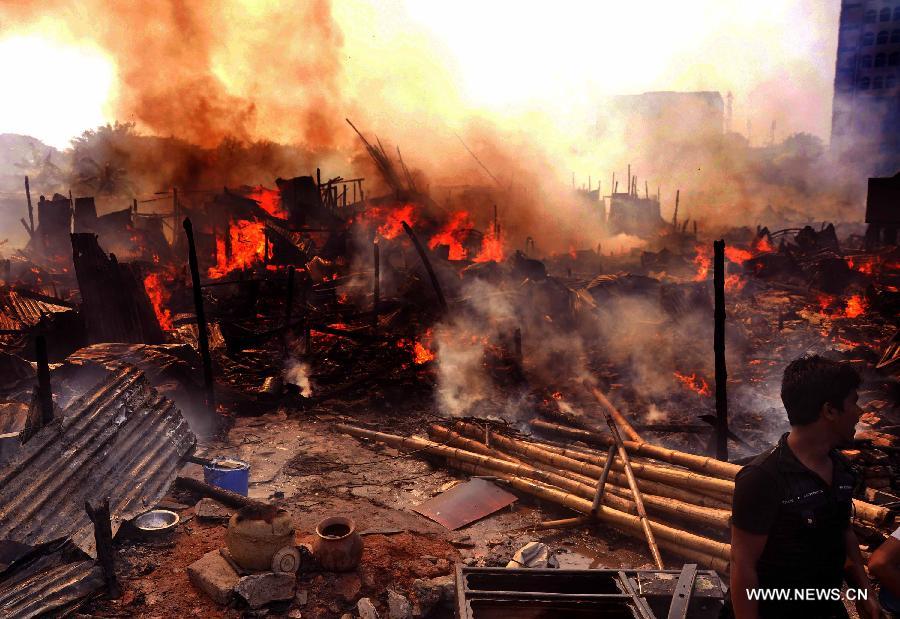 A man cries over a fire accident in a slum in Dhaka, Bangladesh, Feb. 3, 2013. About 100 shanties were destroyed in the accident, official said. (Xinhua/Shariful Islam)