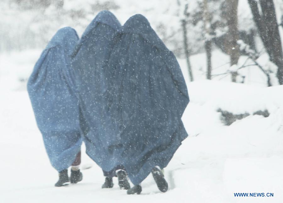 Afghan women walk along a road during heavy snowfall in Kabul, Afghanistan, on Feb. 2, 2013. Over the past two weeks, at least 17 people, 11 of them children, have died because of cold-related diseases in Afghanistan's resettlement areas, according to media reports. (Xinhua/Ahmad Massoud)