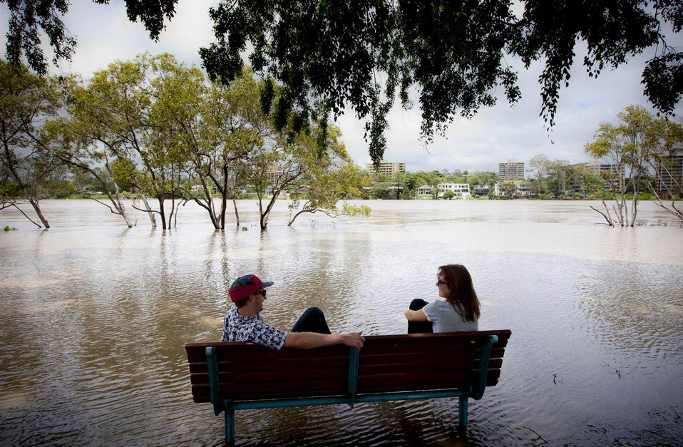 Two guys sit on a bench surrounded by floodwaters as the Brisbane River brakes its banks at West End in Queensland's state capital Brisbane on Jan. 28, 2013. Deadly floodwaters were sweeping down Australia's east coast Tuesday, with Brisbane bracing for its river to peak as other towns waited anxiously as waters rose. (Xinhua News Agency/AFP)