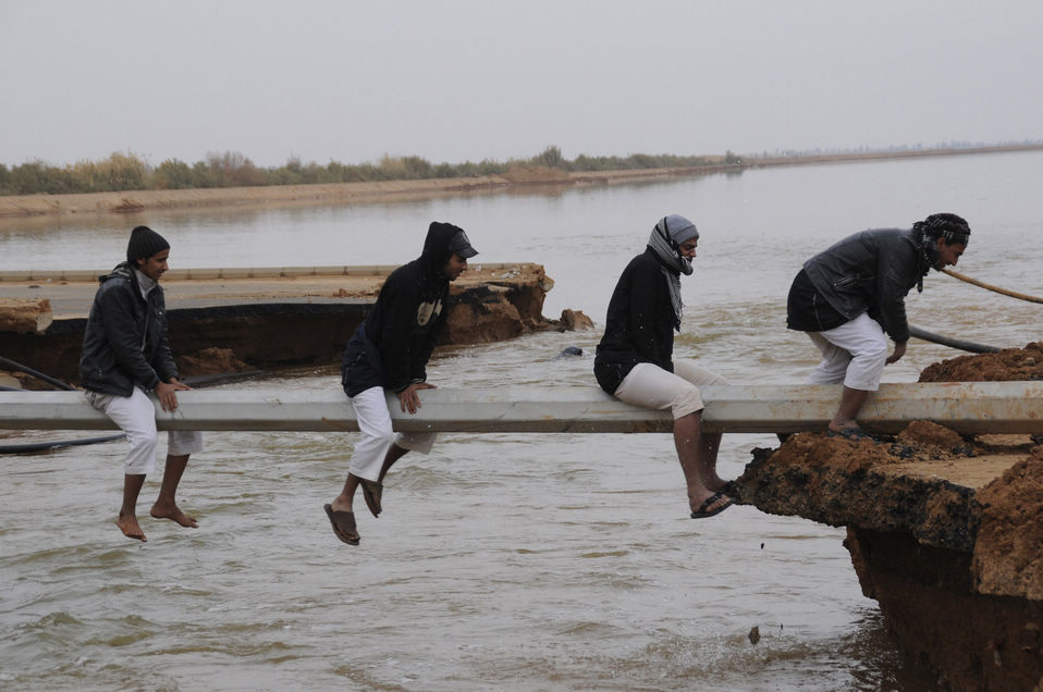 People get creative and cross a flooded area after heavy rain in Tabuk, Saudi Arabia on Jan. 30, 2013. (Xinhua News Agency/Reuters)