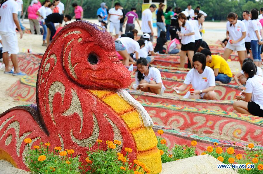 Workers create the snake sand statue on the Sentosa Island, Singapore, Feb. 4, 2013. The flower show on the Sentosa Island to celebrate the Spring Festival opens from Feb. 9 to 17. (Xinhua/Then Chih Wey) 