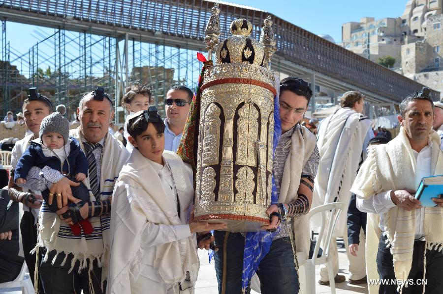 A 13-year-old Jewish boy (C) is surrounded by his family members during his Bar Mitzvah ceremony to be recognized by Jewish tradition as having the same rights as a fully grown man, at the Western Wall Plaza in Jerusalem's Old City on Feb. 4, 2013. (Xinhua/Yin Dongxun)