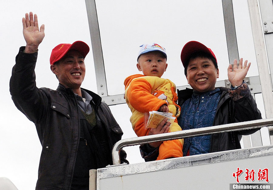 Outstanding migrant worker Zhang Zhi with his wife and grandson wave hands to say goodbye to Fuzhou before leaving. (CNS/Liu Kegeng)