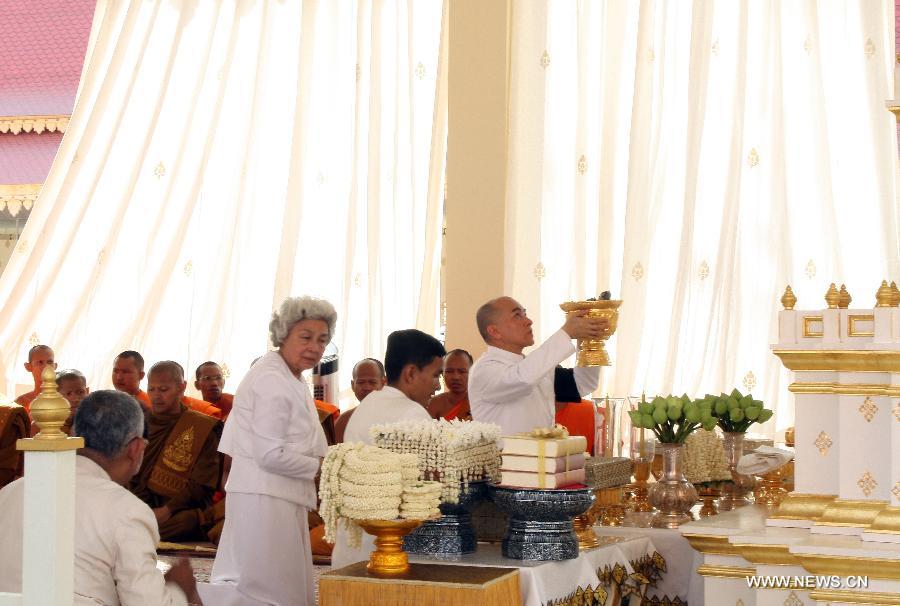 Cambodian King Norodom Sihamoni holds up a golden urn of late King Father Norodom Sihanouk's ashes at a cremation site next to the royal palace in Phnom Penh, capital of Cambodia, on Feb. 5, 2013. Cambodian royal families brought late King Father Norodom Sihanouk's ashes to scatter at the confluence of four rivers in front of the capital city's royal palace on Tuesday after his body was cremated. (Xinhua/Sovannara)