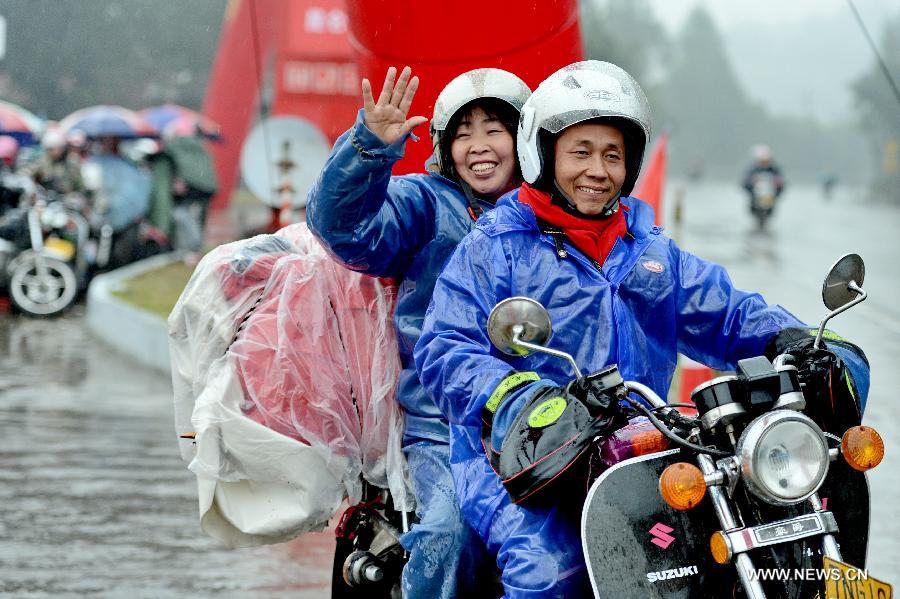 A migrant worker couple from east China's Jiangxi Province set forth a homebound motorcycle journey in Fuzhou, capital of southeast China's Fujian Province, Feb. 5, 2013. Many migrant workers in China choose motorcycle as the means of transport when they return to their hometowns for family reunion during the Spring Festival. (Xinhua/Zhang Guojun) 