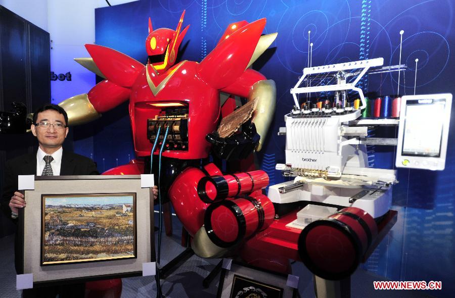 A visitor demonstrates the work of a weaver robot in a newly inaugurated robot pavilion at Taipei Expo Park in Taipei, southeast China's Taiwan, Feb. 6, 2013. The robot pavilion was inaugurated Wednesday at the Xinsheng Park of Taipei Expo Park. The facility features 60 robotic exhibits. (Xinhua/Wu Ching-teng) 