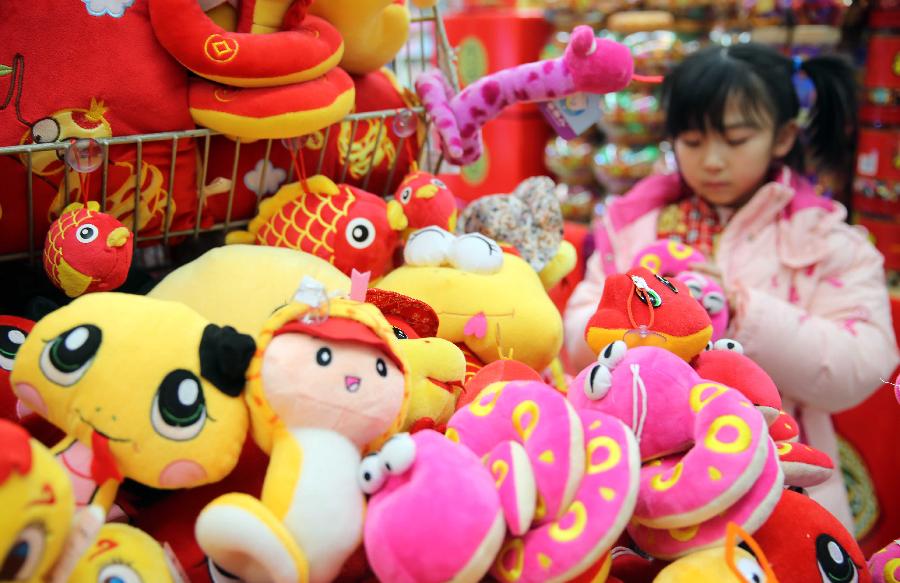 A girl selects toys at a supermarket in Sanhe City, north China's Hebei Province, Feb. 7, 2013, to prepare for the coming Spring Festival, which falls on Feb. 10 this year. (Xinhua/Liang Zhiqiang)