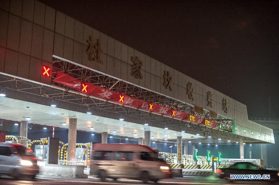 Cars move through a toll gate of highway in Beijing, capital of China, on Feb. 9, 2013. The highways in China will be toll-free for passenger cars from 0:00 on Feb. 9 to 24:00 on Feb. 15 when most Chinese will go home for the Spring Festival and return to work. (Xinhua/Zhang Yu) 