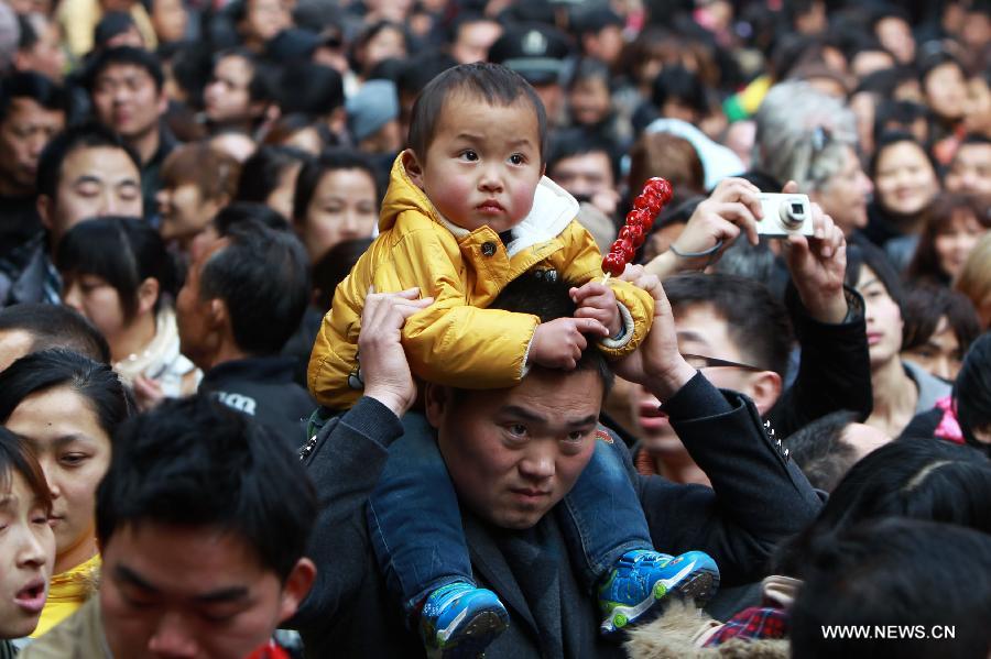 A child sits on a man's shoulders as they visit a scenic spot in east China's Shanghai Municipality, Feb. 10, 2013. Shanghai saw a tourist peak on Sunday, the first day of the 2013 Spring Festival holiday. The city is estimated to receive more than three million tourists during the week-long holiday. (Xinhua/Ding Ting) 