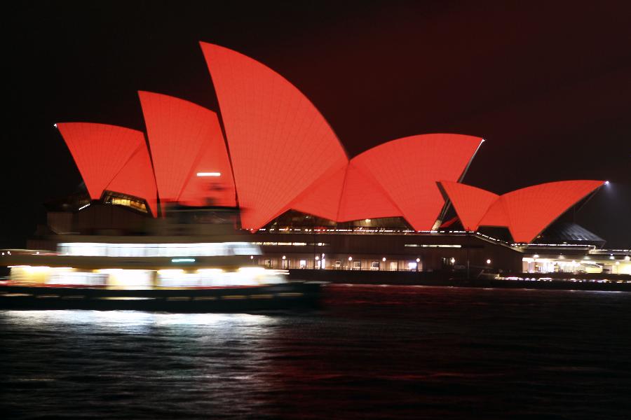 A ferry boat moves in the front of the Sydney Opera House, which is lit up in red to celebrate the Chinese lunar New Year, in Sydney, Australia, on Feb. 10, 2013. The Chinese Spring Festival falls on Feb. 10 this year, marking the start of the Chinese Year of the Snake. (Xinhua/Jin Linpeng) 
