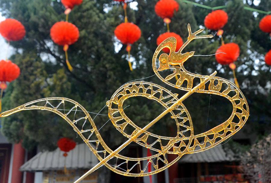 A "snake" made of sugar coils round a stick is seen at a temple fair in Zhengzhou, capital of central China's Henan Province, Feb. 10, 2013. Chinese people ushered in the Year of the Snake on Feb. 10 and various snake handicrafts can be seen at temple fairs, a Chinese cultural gathering usually held around the time of the Chinese New Year. (Xinhua/Wang Song) 