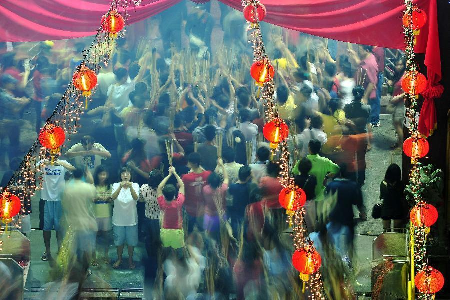 Overseas Chinese pray for good fortune at a temple along Waterloo Street in Singapore on the eve of the Lunar New Year on Feb. 9, 2013. (Xinhua/Then Chih Wey)