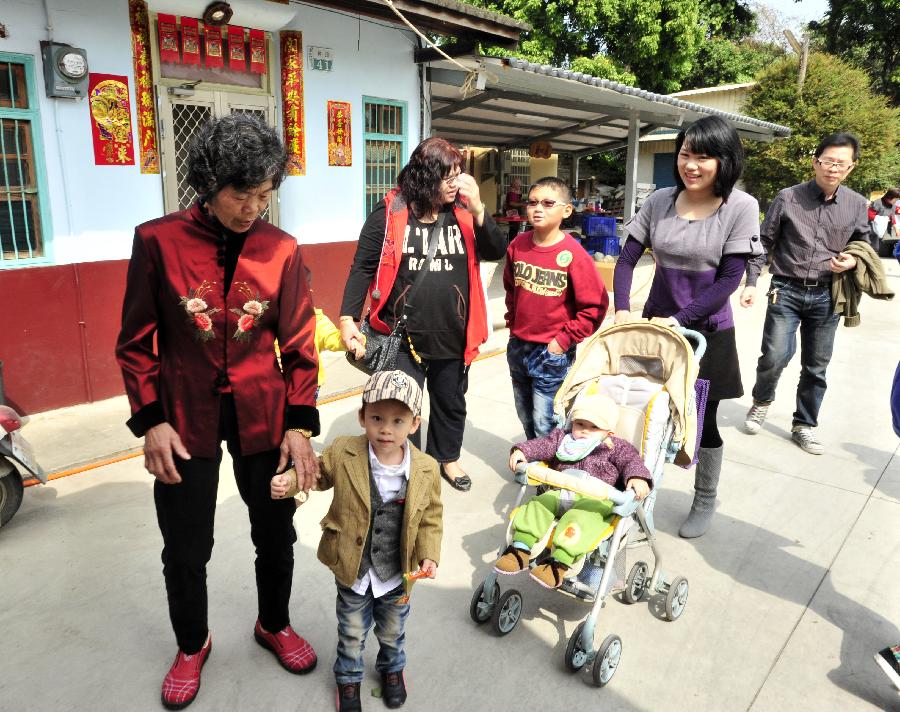A family surnamed Wu welcome their daughter, son-in-law and grandchildren to return home in Chiayi County, southeast China's Taiwan, Feb. 11, 2013. It is the second day of this year's Lunar New Year, or Spring Festival, on Feb. 11, when Chinese married women usually follow a tradition to visit parents with their husbands. (Xinhua/Wu Ching-teng)