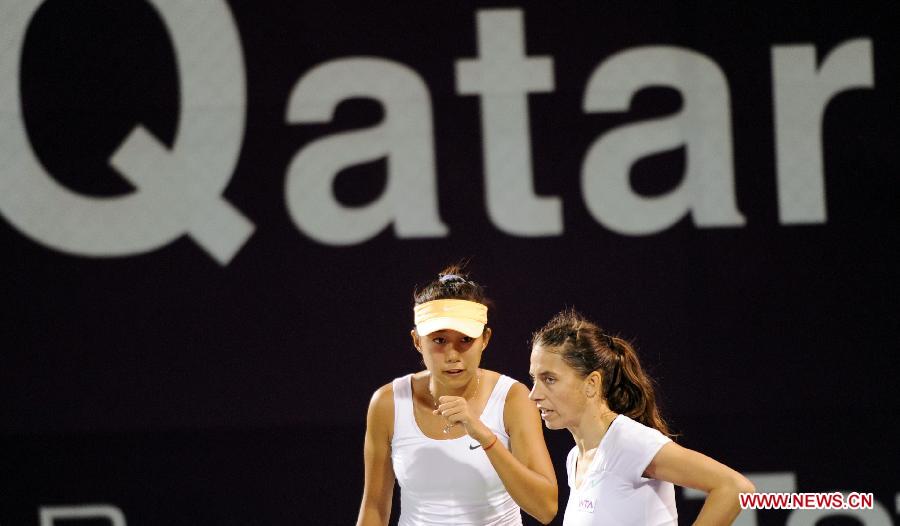 Zhang Shuai (L) of China talks to Janette Husarova of Slovakia during the doubles match on the first day of the WTA Qatar Open against Natalie Grandin of South Africa and Vladimira Uhlirova of the Czech Republic in Doha, Qatar, Feb. 11, 2013. Zhang Shuai and Husarova won 2-1. (Xinhua/Chen Shaojin) 