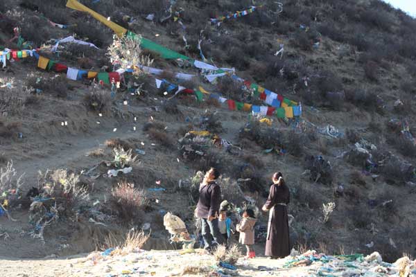 A tibetan family sprays his prayer papers into the sky. [Photo/China Tibet Online]