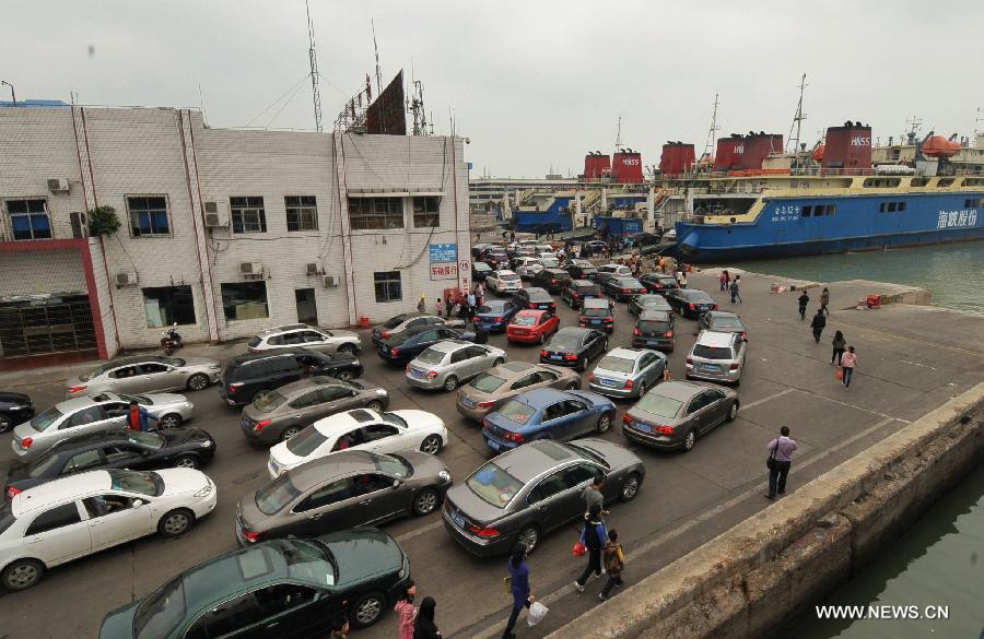 Vehicles which were detained by a heavy fog leave a port in Haikou, capital of south China's Hainan Province, Feb. 16, 2013. A total of 46,000 passengers and 8,700 vehicles have left the Port of Haikou from 8:00 p.m. Friday to 8:00 a.m. Saturday, after being detained by a heavy fog that disrupted the waterway traffic across the Qiongzhou Strait. (Xinhua/Wei Hua)  