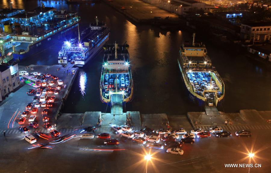 Vehicles which were detained by a heavy fog leave a port in Haikou, capital of south China's Hainan Province, late Feb. 15, 2013. A total of 46,000 passengers and 8,700 vehicles have left the Port of Haikou from 8:00 p.m. Friday to 8:00 a.m. Saturday, after being detained by a heavy fog that disrupted the waterway traffic across the Qiongzhou Strait. (Photo/ Xinhua)  
